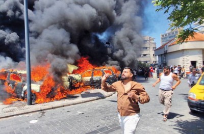 أشخاص يركضون فيما تحترق سيارات بعد غارات إسرائيلية على مدينة صيدا الجنوبية
