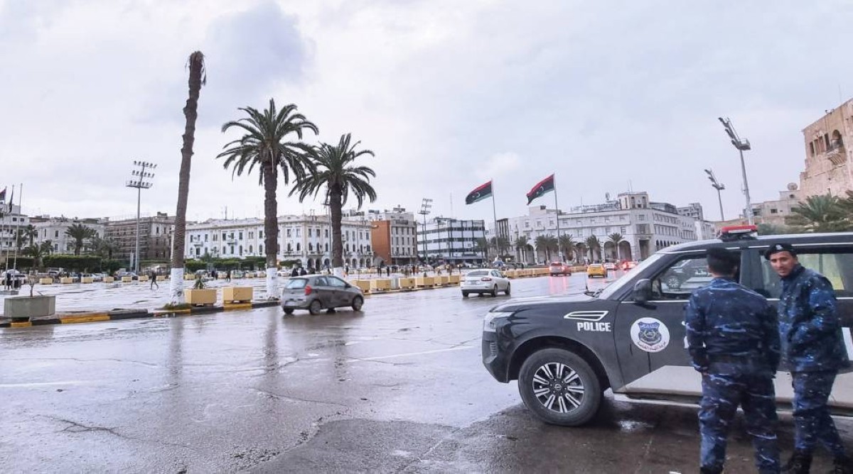 رجال الشرطة بجانب سيارة دورية في ساحة الشهداء بالعاصمة طرابلس