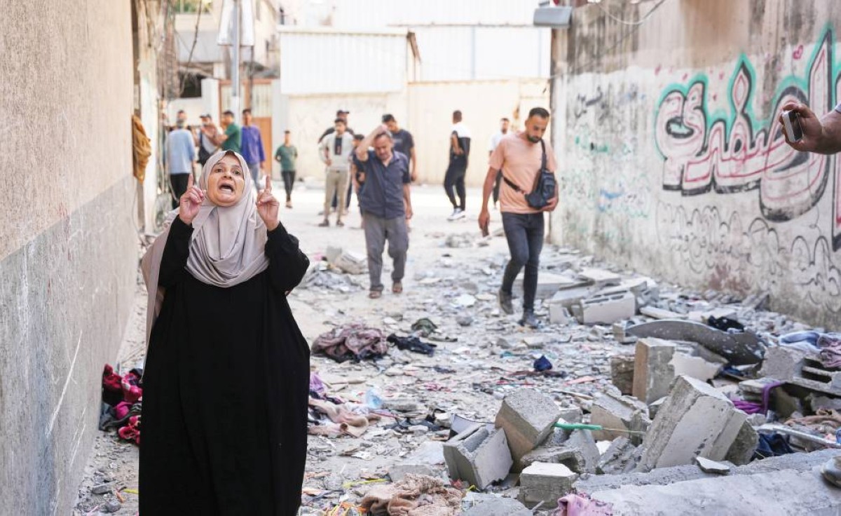 فلسطينيون يتفقدون أنقاض شقة عائلة قتلت عقب غارة جوية إسرائيلية على غزة
