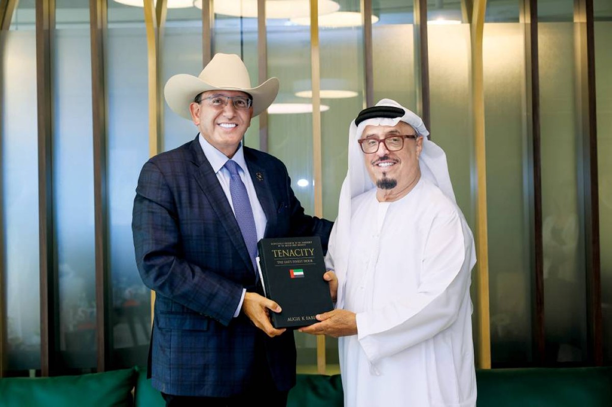 ضاحي خلفان خلال تسلمه الكتاب من أوغي ك. فابيلا الثاني