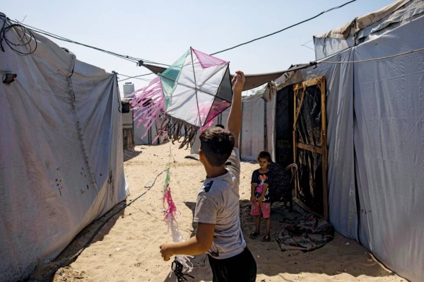 طفل فلسطيني يلعب بطائرة ورقية في مخيم المواصي قرب خان يونس