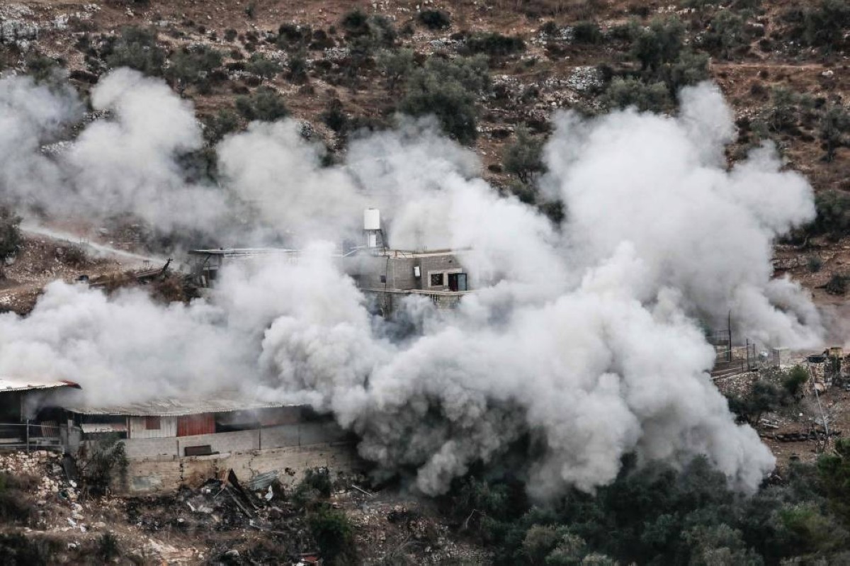 الدخان يتصاعد من منزل أسير فلسطيني أثناء تفجيره من قبل الجيش الإسرائيلي في قرية بيت عمرين بالضفة / أ.ف.ب