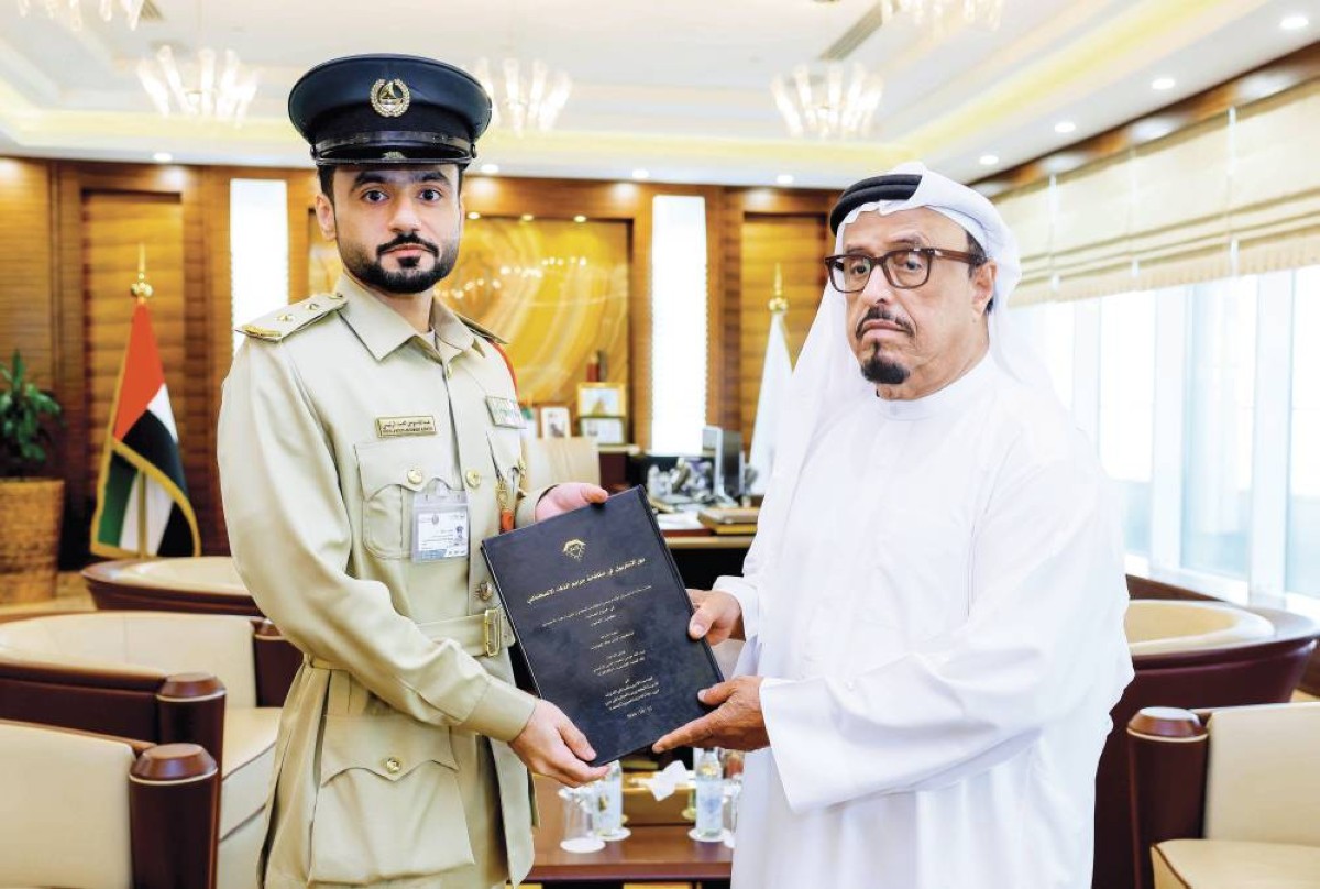 ضاحي خلفان متسلماً النسخة من عبدالله الرئيسي