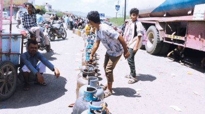 فتية يصطفون ومعهم أسطوانات غاز الطهي بانتظار إعادة تعبئتها وسط نقص في الإمدادات في تعز باليمن