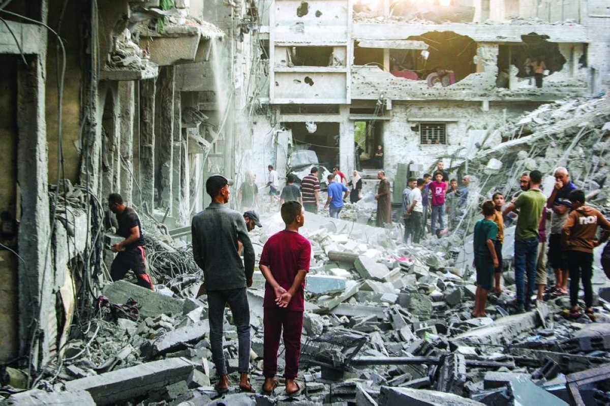 فلسطينيون يتفقدون أنقاض منازل مدمرة عقب غارة جوية إسرائيلية على حي الصبرة في مدينة غزة | إي بي إيه