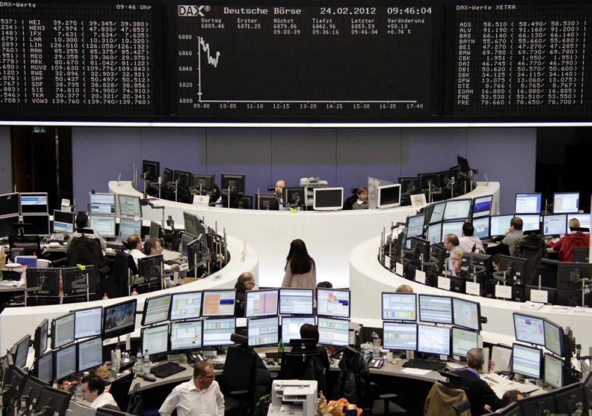 Traders are pictured at their desks in front of the DAX board at the Frankfurt stock exchange February 24, 2012. REUTERS/Remote/Kirill Iordansky (GERMANY - Tags: BUSINESS)