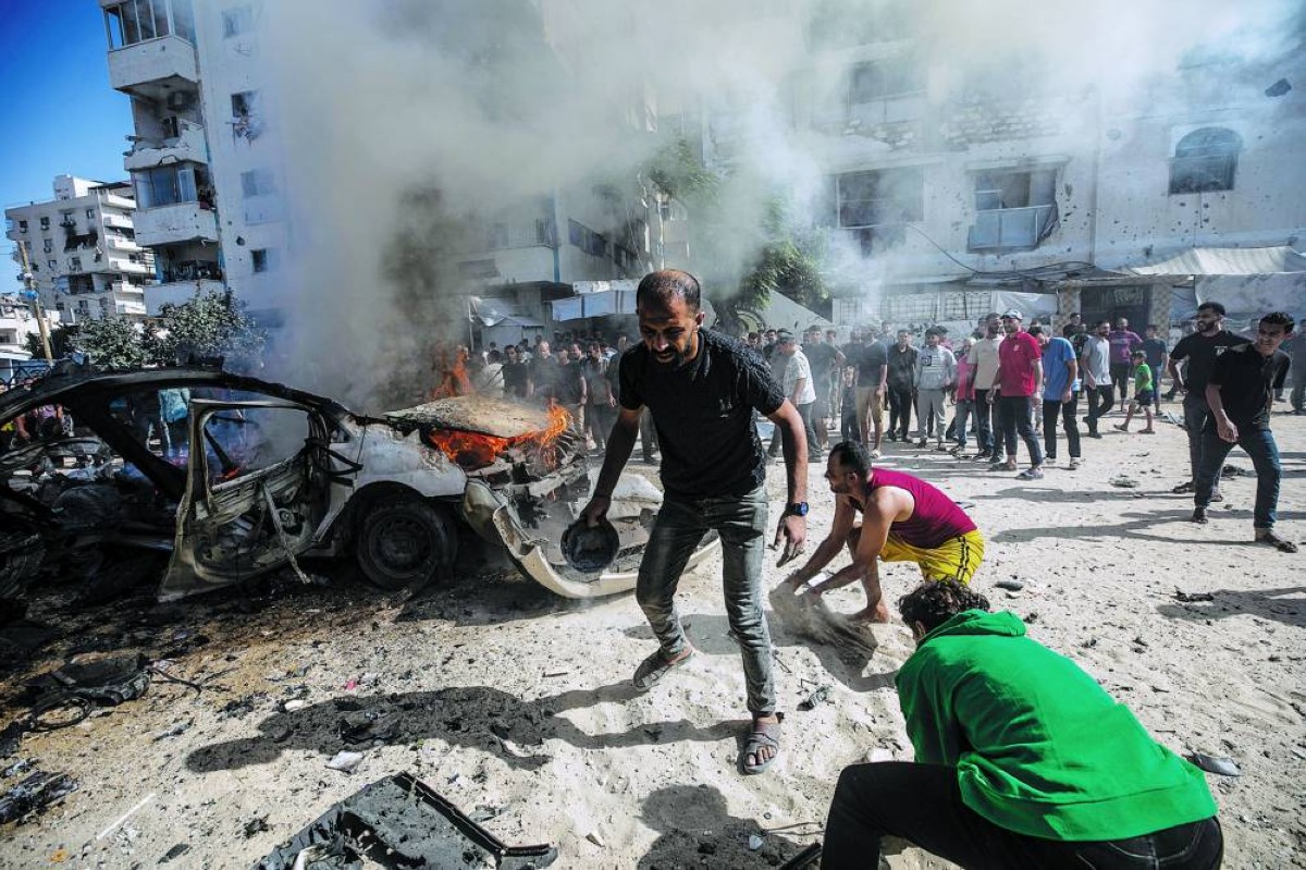 فلسطينيون يحاولون إخماد حريق في مركبة استهدفتها غارة إسرائيلية جنوب مدينة غزة