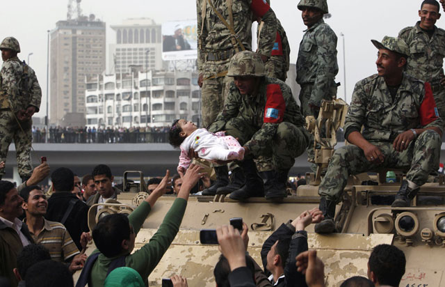 الصورة: جندي يحمل طفل أحد المتظاهرين في القاهرة، 29 يناير 2011
