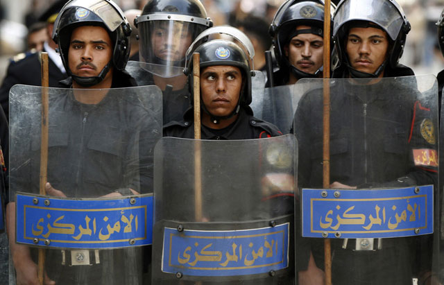 الصورة: شرطة مكافحة الشغب تشكل جداراً أمنياً خلال اشتباكات مع محتجين في القاهرة، 26 يناير 2011