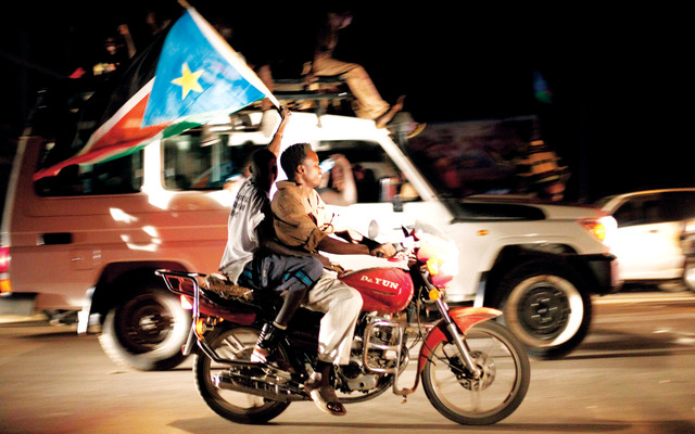 الصورة : جنوبيان يحتفلان في أحد شوارع جوبا رافعين علم الدولة الجديدة (إي.بي.إيه)