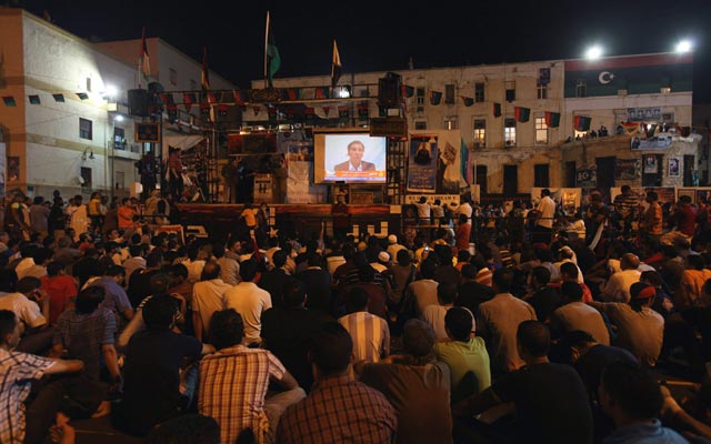 الصورة: ليبيون يشاهدون خطاب المنشق الليبي عبد السلام جالود بالقرب من مبنى محكمة في بنغازي. رويترز