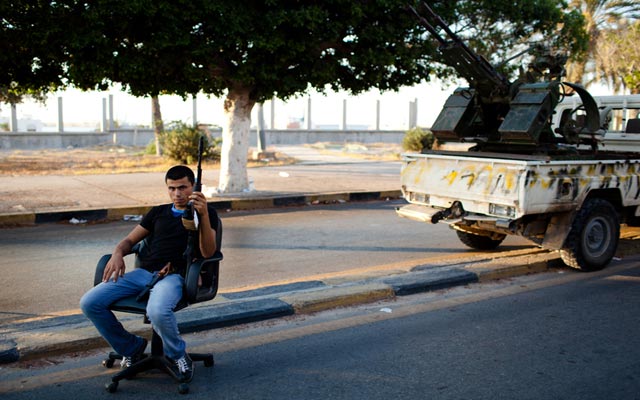 الصورة: مقاتل يجلس في نقطة التفتيش في مدينة طرابلس. رويترز