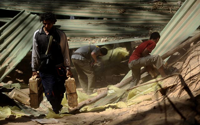 الصورة: ثوار يستولون على صناديق ذخيرة أخفتها قوات القذافي تحت أرض غابة آل المازر في طرابلس اف ب