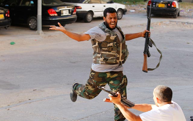 الصورة: مقاتل يصرخ في وجه رفيقه طالبا منه وقف اطلاق النار على المباني في معركة بمنطقة أبو سالم. رويترز