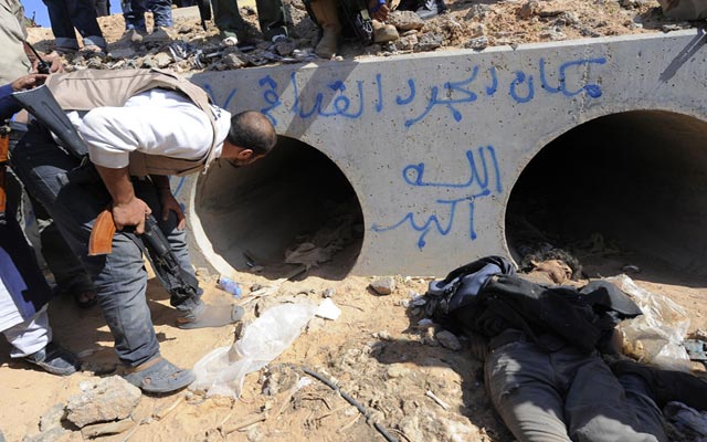 الصورة: ثوار ليبيا يتفحصون مخبأ القذافي في سرت