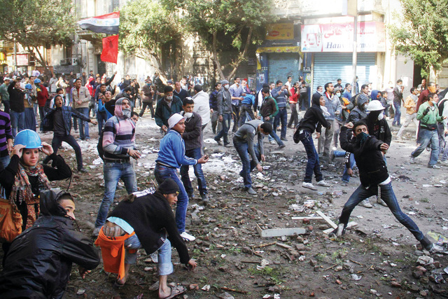 الصورة : متظاهرون يحملون مصاباً إثر المواجهات العنيفة مع قوات الأمن أمس