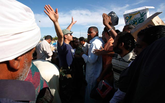 الصورة: مدنيين في سرت يحتشدون لتلقي حصصهم الغذائية اليومية التي تم التبرع بها من مختلف المدن الليبية. رويترز