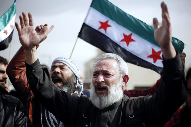 الصورة : سوري متضامن مع المحتجين خلال تظاهرة مطالبة بالتدخل الدولي في العاصمة الأردنية عمان