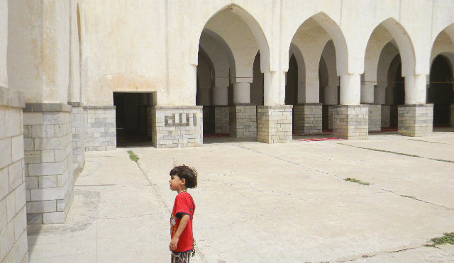 الصورة : مداخل المسجد وطفل في انتظار والده لاداء الصلاة