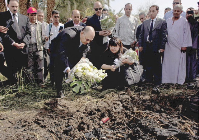 الصورة : وفود أجنبية ومصرية تضع أكليلاً من الورود على مكان وقوع منطاد في الأقصر حيث قتل الثلاثاء 19 سائحاً.						              ا.ب
