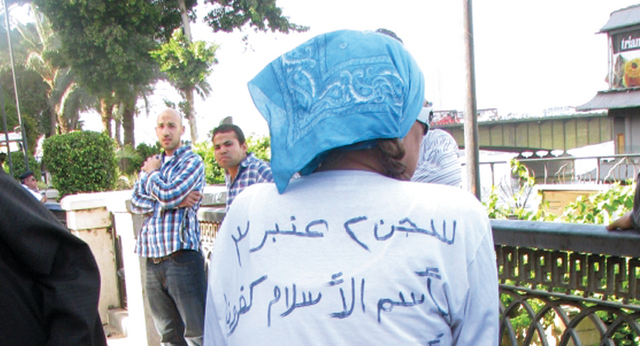 الصورة: مواطنة مصرية تنتظر التوقيع على استمارة «تمرّد» وكتبت على ظهرها عبارات تندّد بـ «الإخوان»