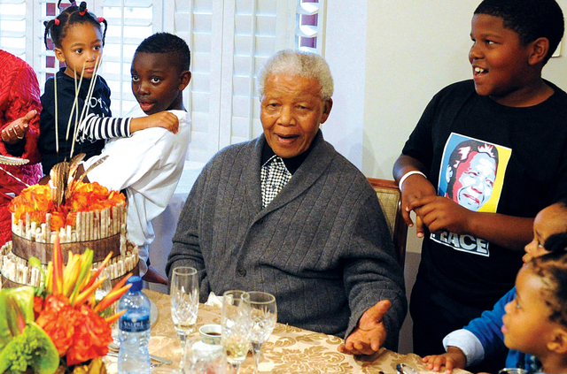 الصورة : مانديلا يحتفل بعيد ميلاده الـ94 في يوليو 2012 وسط أفراد عائلته أ.ف.ب