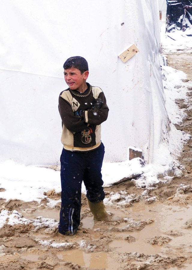 الصورة : طفل سوري لاجئ يقف على بركة من الطين في مخيم وادي البقاع شرق لبنانأ.ف.ب