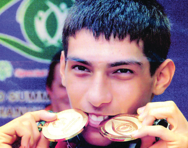 الصورة : عبدالله التاجر يقبل الميداليات الذهبية بعد فوزه في إحدى البطولات