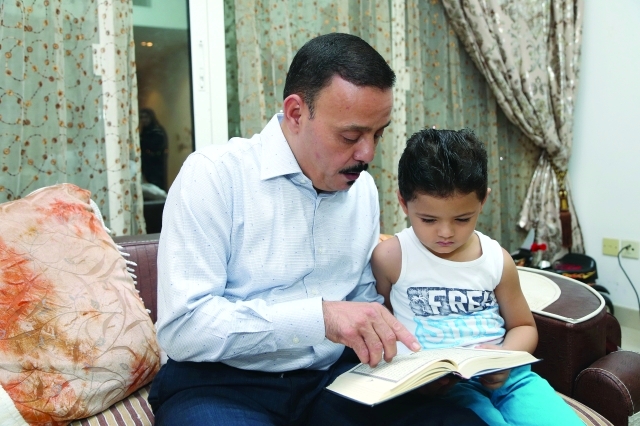 الصورة : .. مع حفيده ايمن خلال قراءة القرآن الكريم