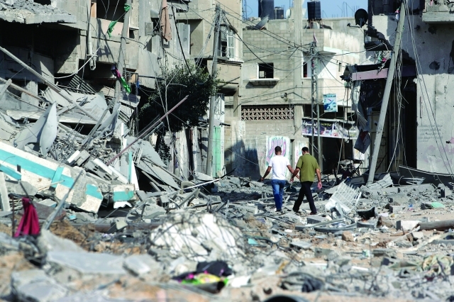 الصورة : فلسطيني يسير بين ركام منزل مدمر في بيت حانون                  أ.ب