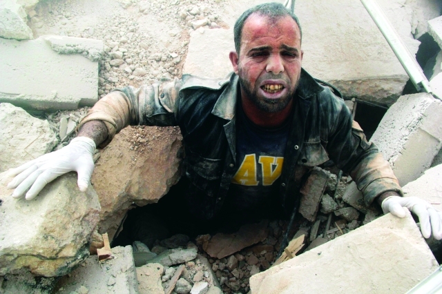 الصورة : عضو في الدفاع المدني عالق تحت الأنقاض في أحد أحياء حلب رويترز
