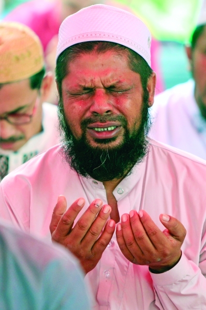 الصورة : بنغالي يتضرع إلى الله بالدعاء والبكاء خلال صلاة العيد في ماليزيا	ا.ب