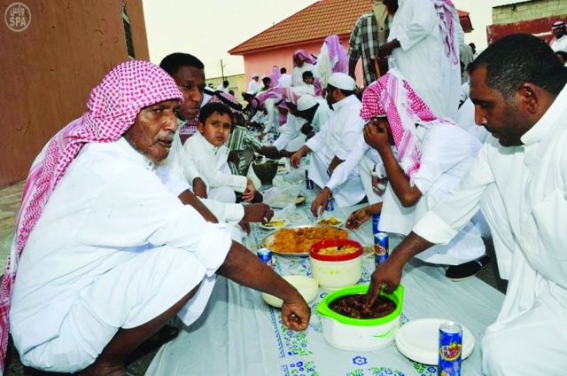 الصورة : مواطنون سعوديون من أهالي جازان يتناولون إفطار العيد 	واس