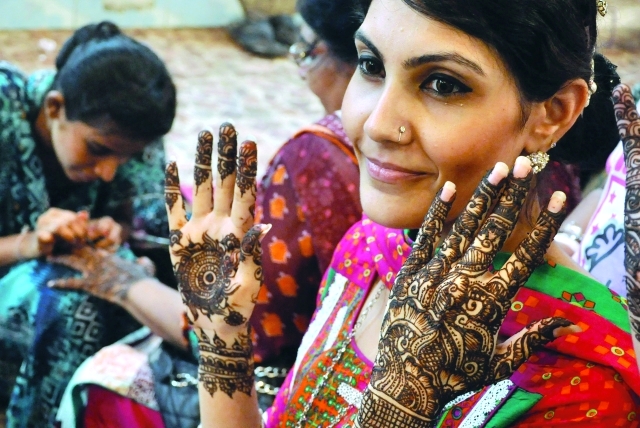 الصورة : باكستانيات يضعن الحناء التقليدية استعداداً للاحتفال   	   إي.بي.إيه