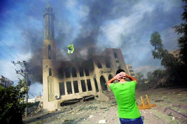 الصورة : الدخان يتصاعد من مسجد الأمين في غزة بعد تعرضه للقصف  	   أ.ف.ب