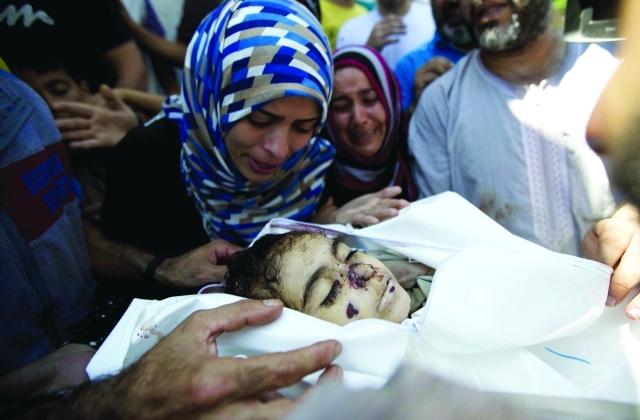 الصورة : أم وخالة الطفلة الشهيدة ليان السلك تبكيانها قبيل تشييعها في غزة                 أ.ف.ب