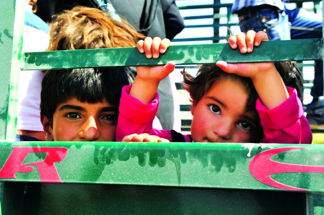 الصورة : أطفال سوريون أثناء إجلائهم من البلدة الحدودية بعد تفجّر القتال  رويترز