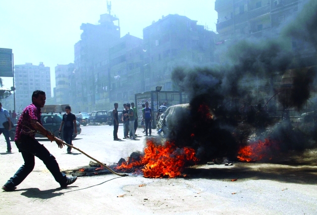 الصورة : أنصار الجماعة الإرهابية يضرمون النار وسط طريق عام في القاهرة  	  أ.ف.ب