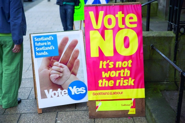 الصورة : ملصقان دعائيان أحدهما مؤيد والآخر رافض لانفصال اسكتلندا أمام مركز اقتراع في أدنبرة	أ.ب