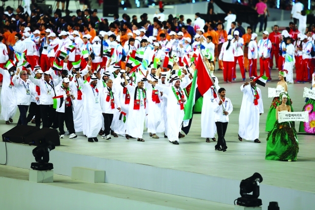 الصورة : جمعة دلموك يحمل علم الدولة خلال الافتتاح
