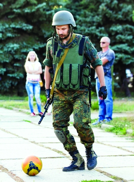 الصورة : جندي أوكراني يلعب الكرة في ماريوبول التي تحوّلت إلى مباراة بين روسيا والغرب.   رويترز
