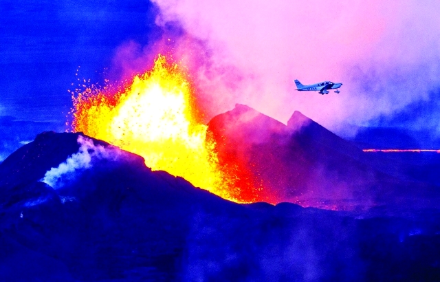 الصورة : طائرة تحلّق فوق بركان يقذف الحمم والدخان جنوب شرقي آيسلندا   		  أ.ف.ب