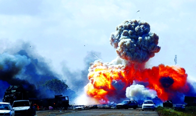 الصورة : النيران تندلع من مركبات موكب القذافي لحظة قصفها في 20 أكتوبر 2011 بين بنغازي وأجدابيا	أرشيفية