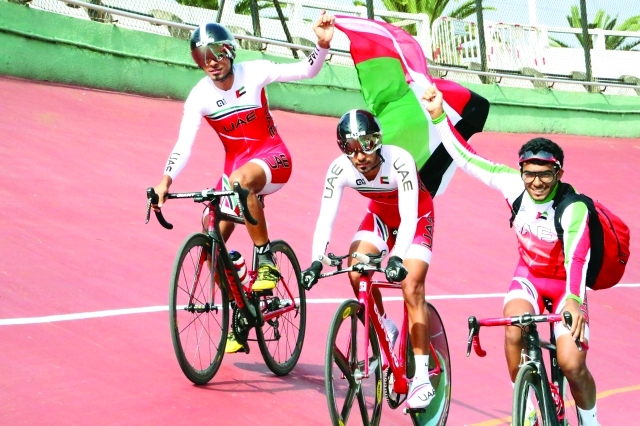 الصورة : نجوم الدراجات يحملون علم الإمارات