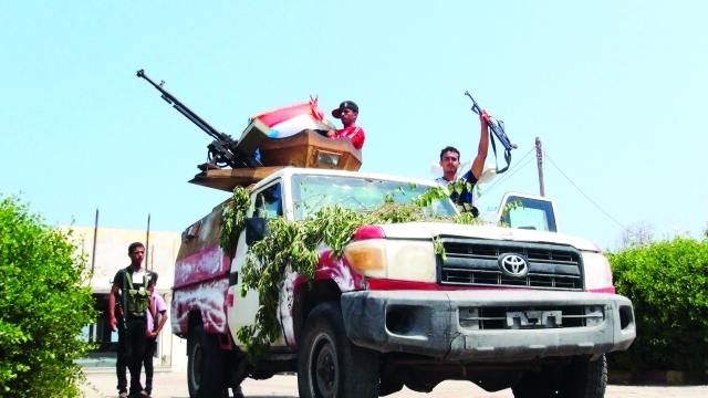 الصورة : مسلحون من اللجان الشعبية الموالين لهادي يقيمون نقطة تفتيش في أحد شوارع عدن  رويترز