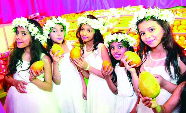 الصورة : فتيات جازان يحتفين بفاكهة المانجو