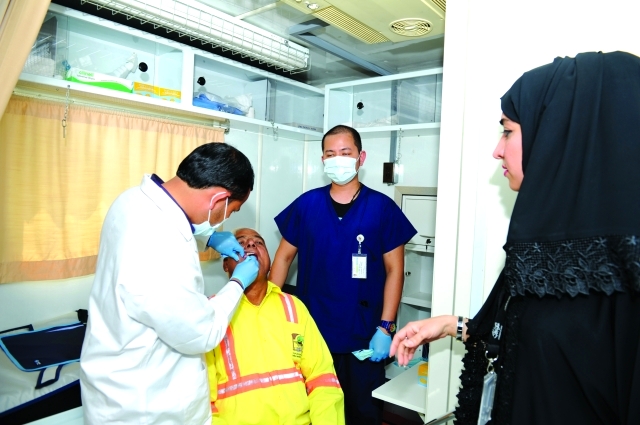 الصورة : ■ طبيب البلدية يعالج أسنان أحد العمال  |  من المصدر