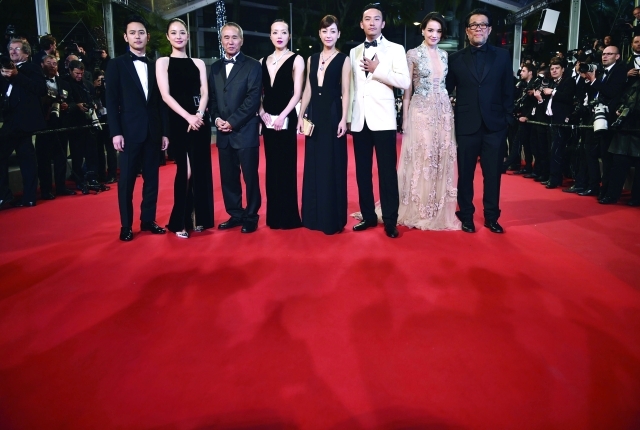 الصورة : ■ المخرج التايواني هو هسياو هسين يتوسط ابطال فيلمه "القتلة المأجورون" على السجادة الحمراء  |   أ ف ب