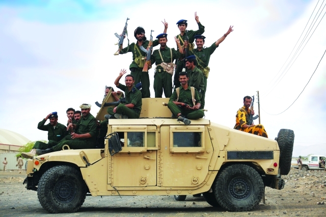 الصورة : Soldiers loyal to Yemen's President Abd-Rabbu Mansour Hadi ride atop a military vehicle during a parade in Yemen's northern province of Marib May 25, 2015. REUTERS/Stringer      TPX IMAGES OF THE DAY