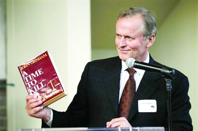 الصورة : جون غريشام يحمل الرواية في الحفل الافتتاحي لمسرحية زمن القتل في واشنطن